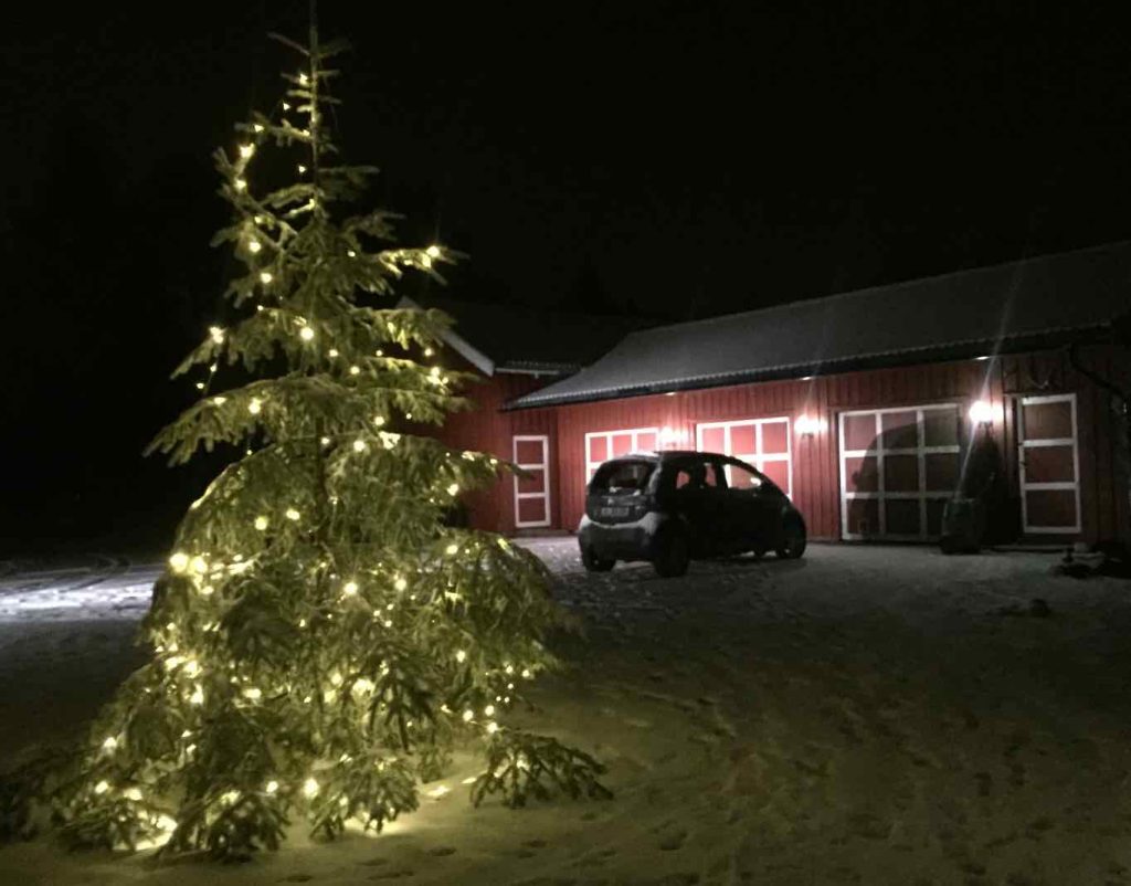 Brukte elbiler: En Citroën C Zero foran en rød låve bak et juletre med lys på